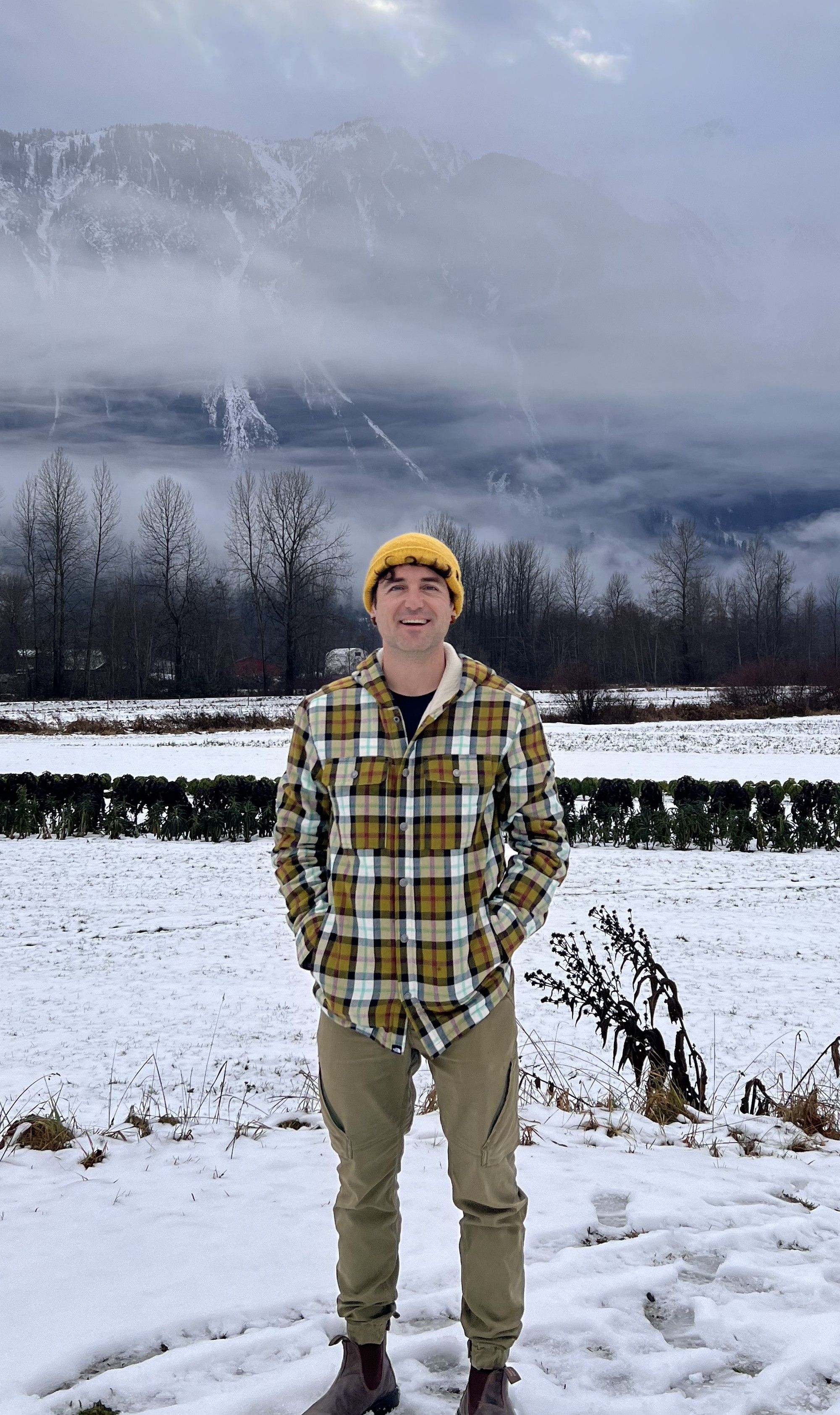 Retrato de Adrià Flor, cofundador de Atypical, con gorro amarillo y camisa de cuadros, en un campo nevado de Whistler.
