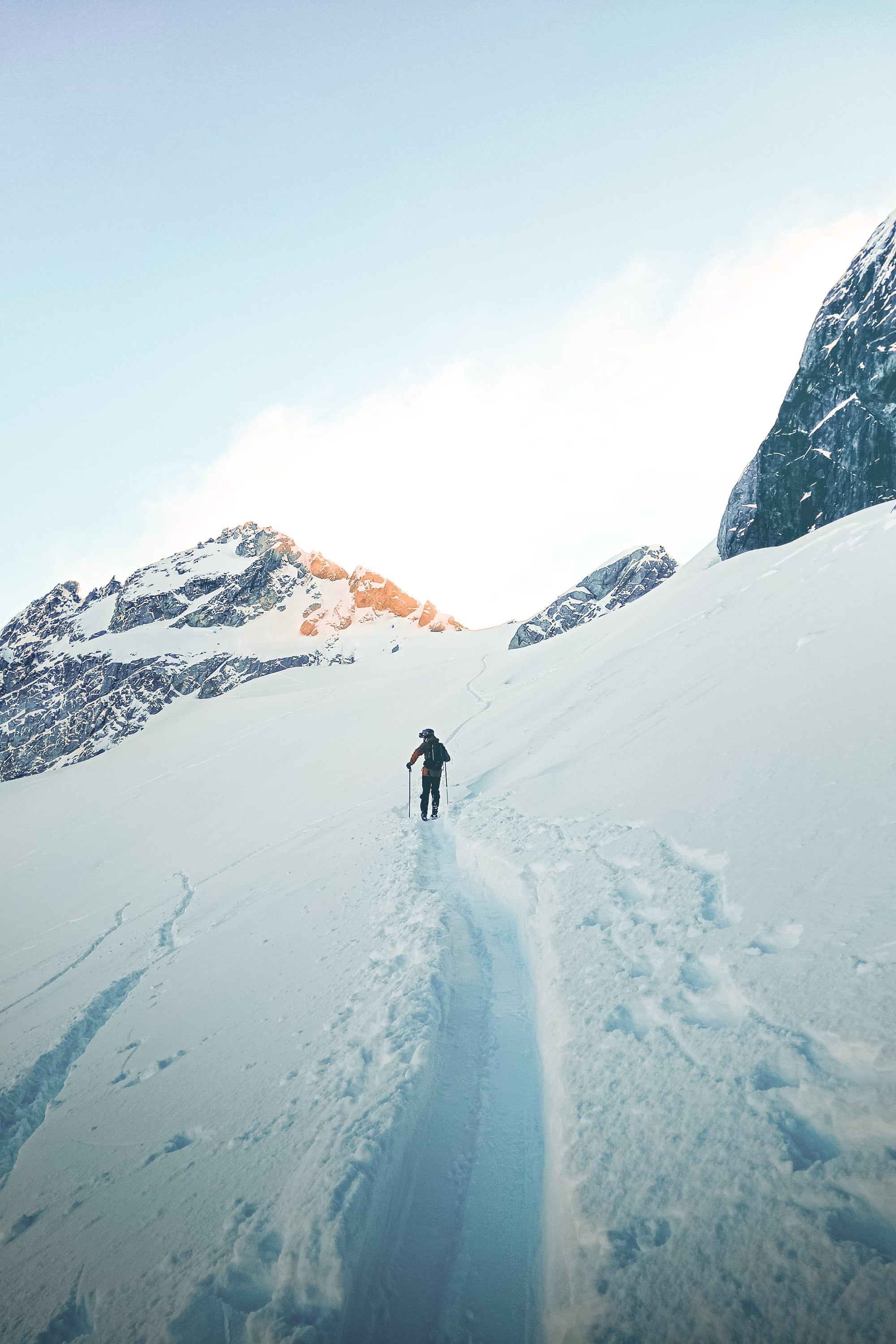 Estudiante haciendo esquí de travesía entre montañas nevadas de British Columbia.