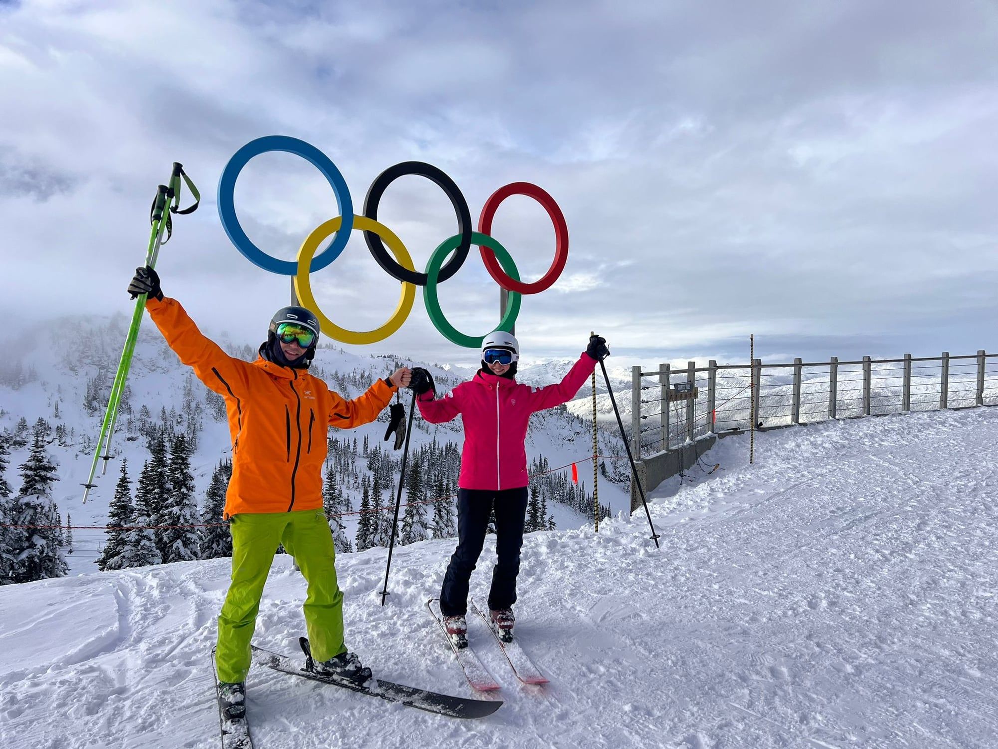 Dos esquiadores ante los anillos olímpicos en la cima de Whistler.