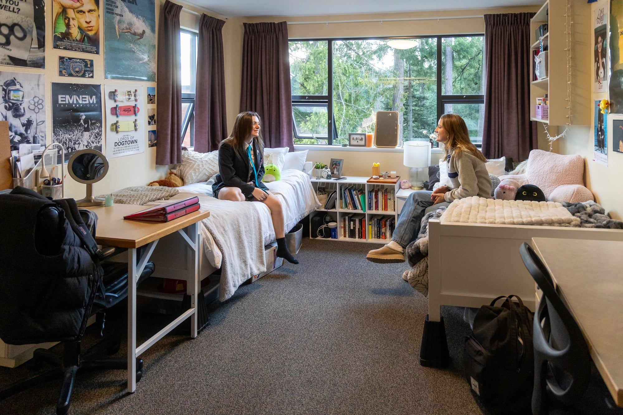 Dos estudiantes conversan en una habitación de la residencia del campus.