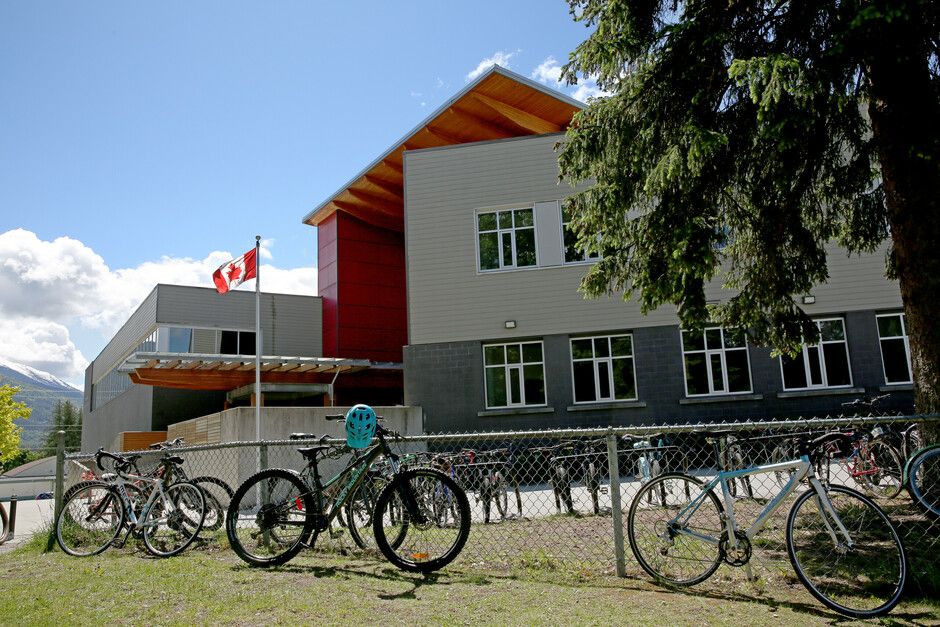 Escuela canadiense con la bandera de Canadá y bicicletas aparcadas.