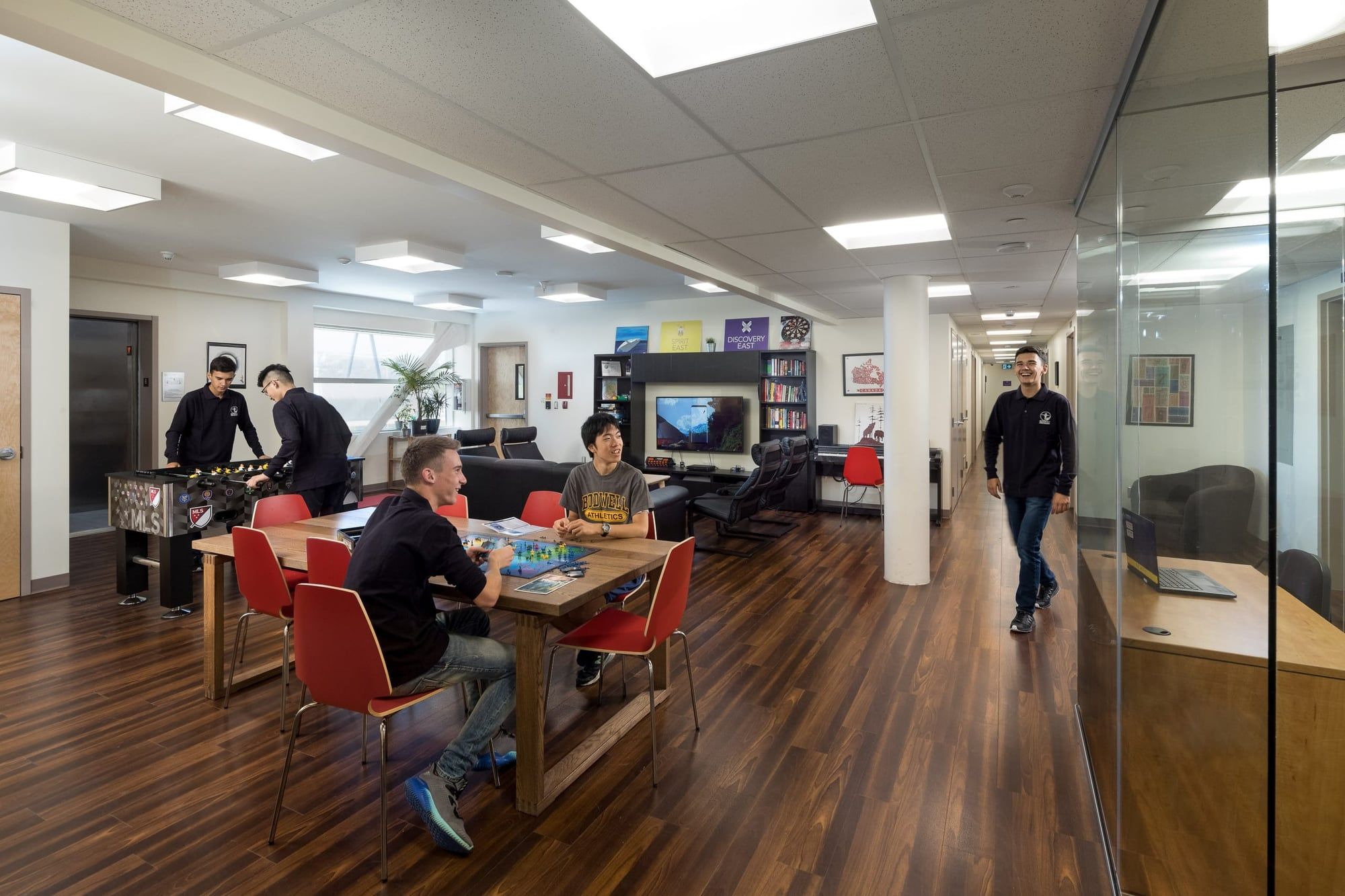 Estudiantes jugando al futbolín en la sala común de su escuela.