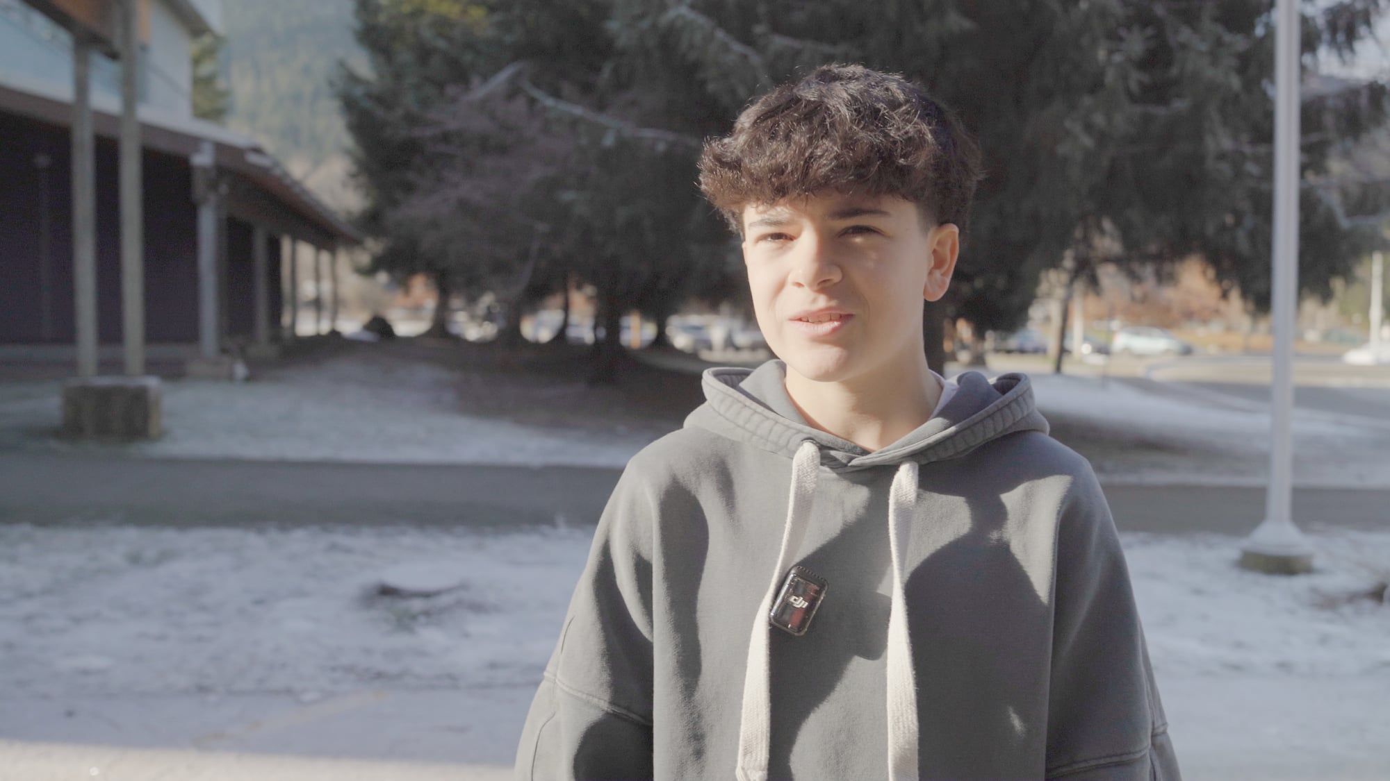 Un adolescente frente a su escuela en un día de invierno en British Columbia.