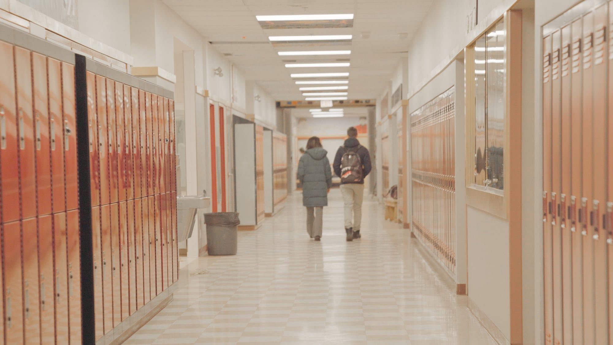 Un acompañante de Atypical camina junto a un estudiante por el pasillo de su escuela en British Columbia.