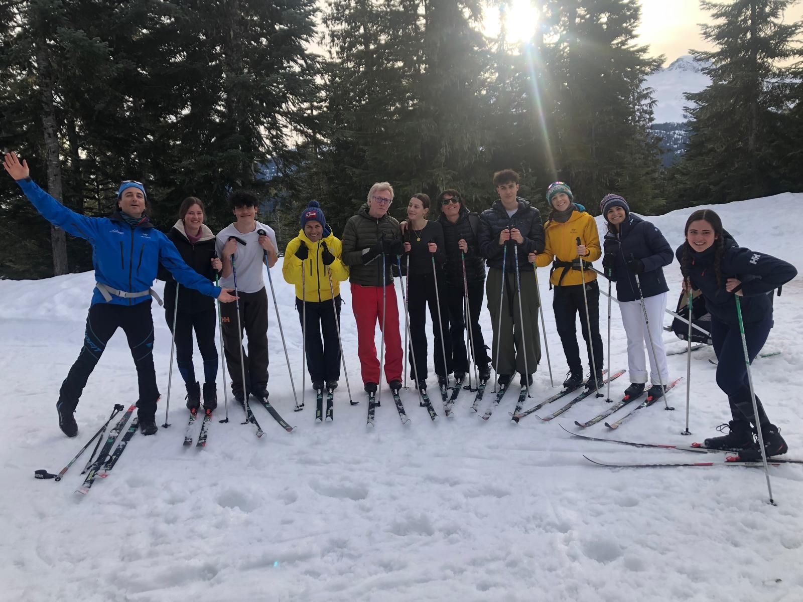 Grupo de estudiantes, familias y acompañantes de Atypical con esquís en la montaña nevada.