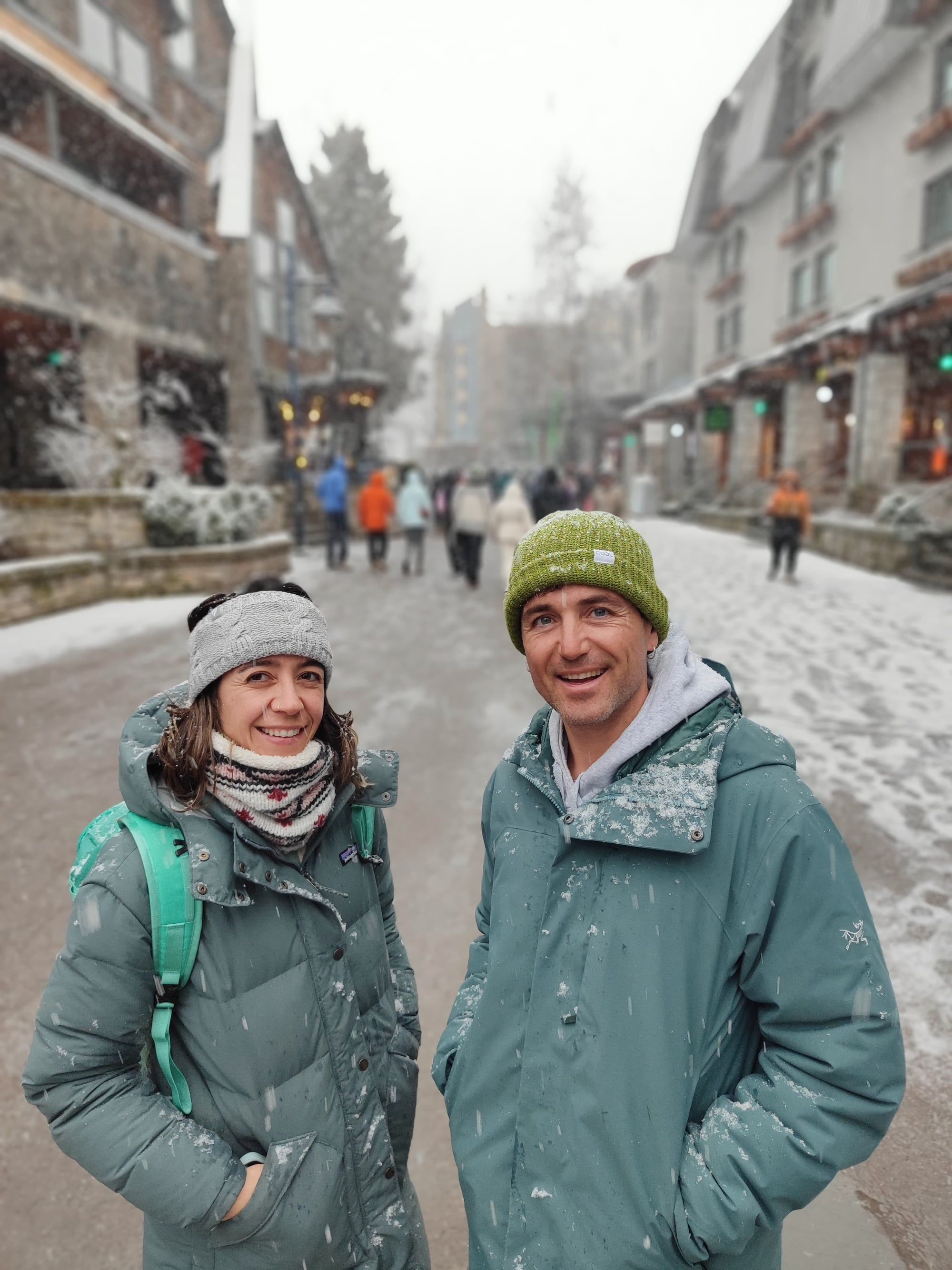 Goretti y Adrià, cofundadores de Atypical, sonriendo en una calle nevada del pueblo de Whistler.