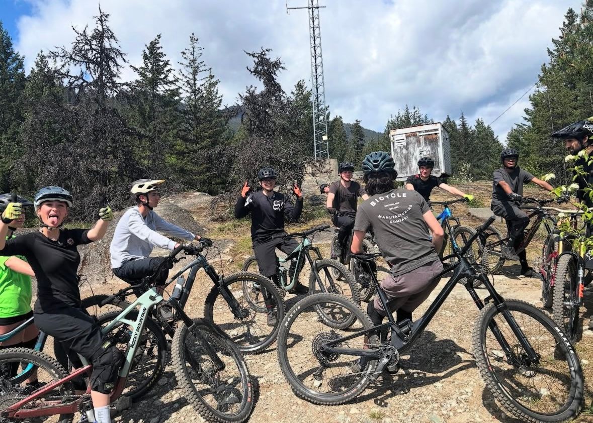 Estudiantes en bicicleta de montaña en un sendero del bosque de British Columbia.